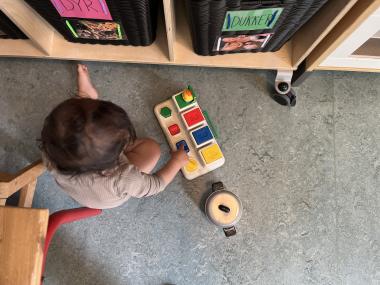 Dreng leger med legetøj på gulvet